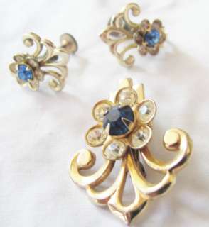 Vintage goldtone metal blue/clear pastestone fleur de lis brooch 